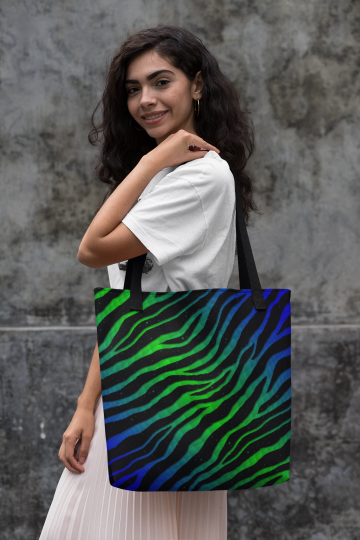 Woman holding a blue/green Ripped Spacetime Stripes tote bag.