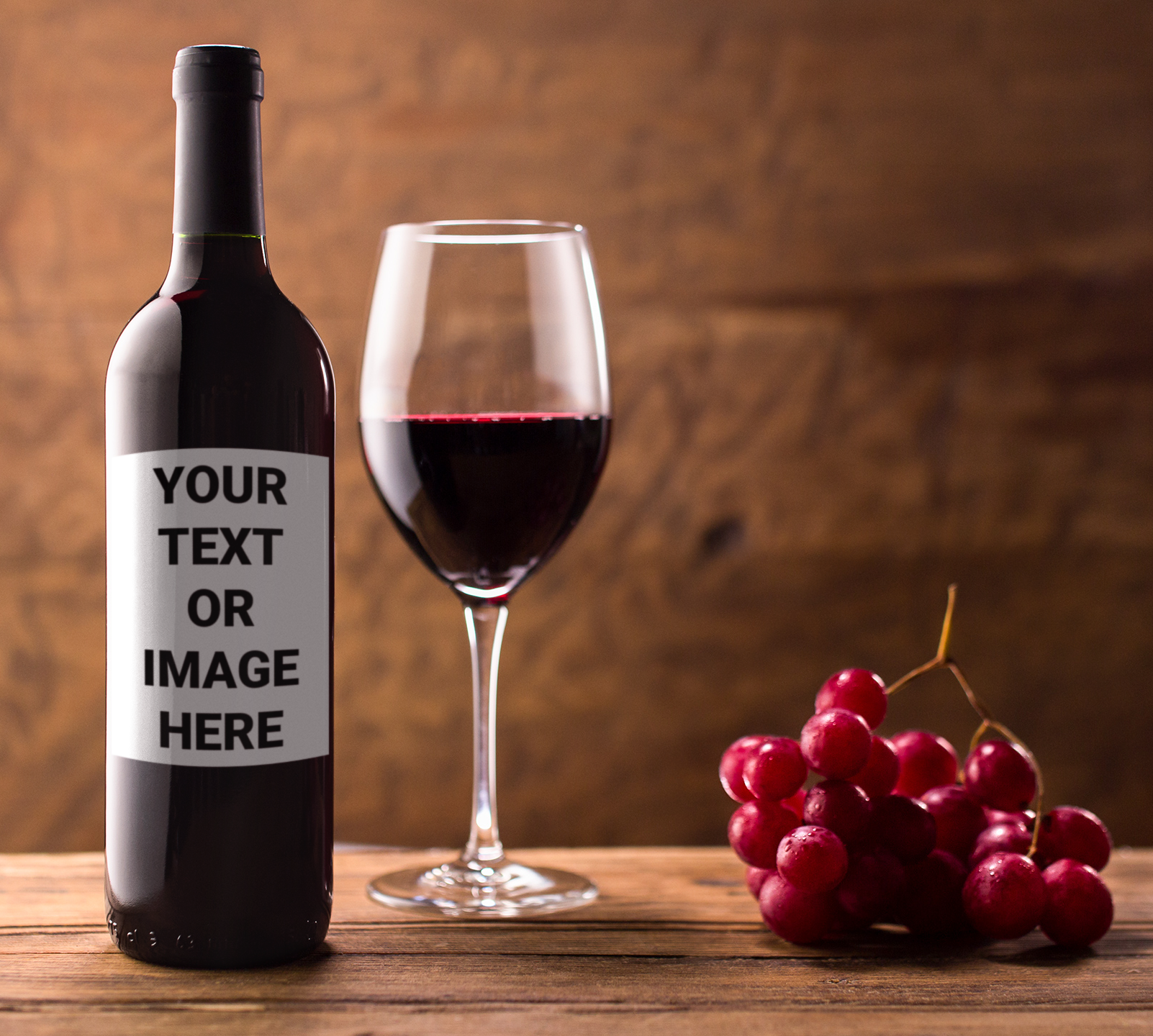 A bottle of wine next to a bunch of grapes that reads: Your Text Or Image Here.