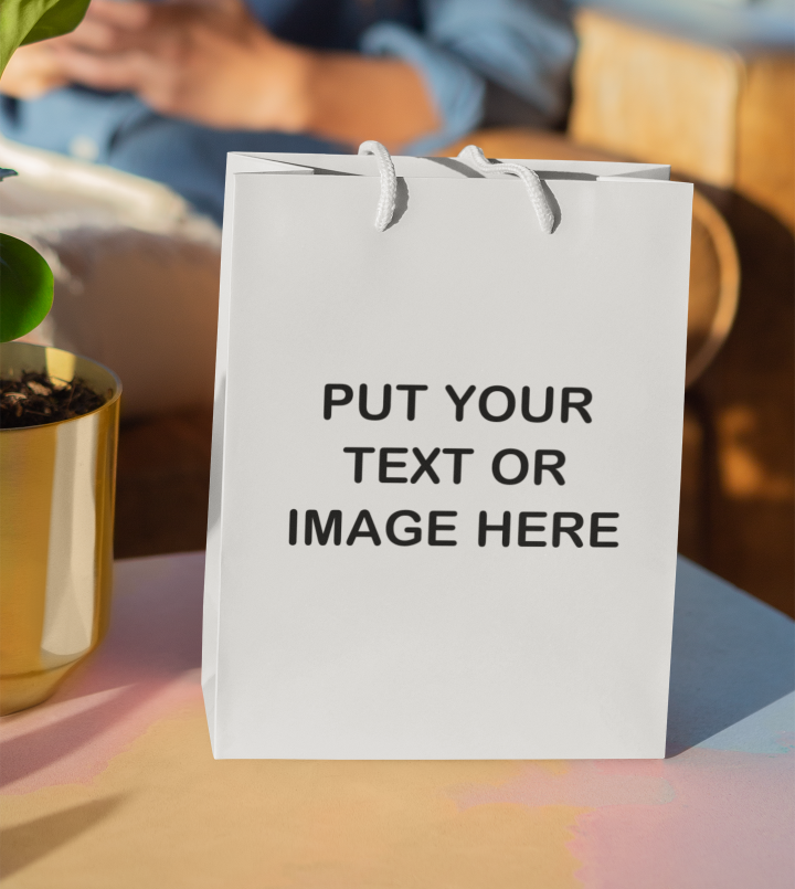 White Your Text Or Image Here gift bag on a table.